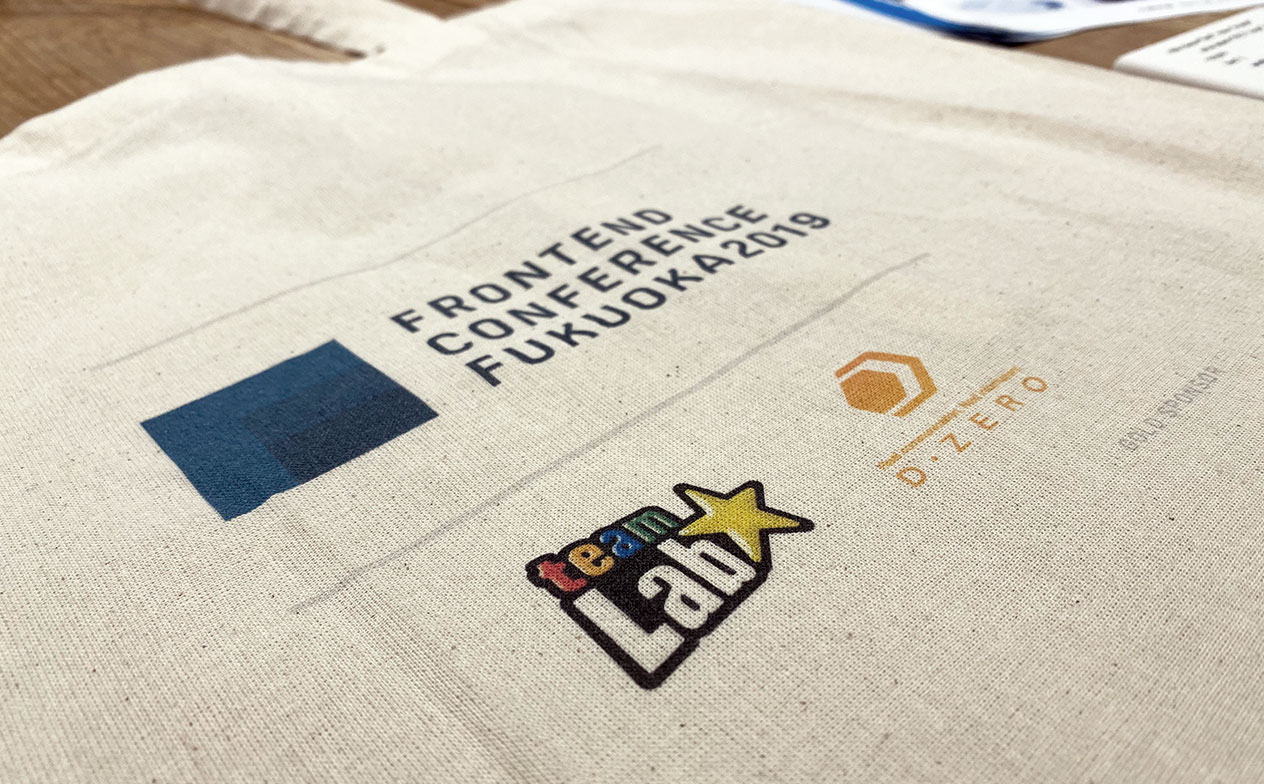 写真：エコバッグにカンファレンスのロゴとゴールドスポンサーのロゴが印刷されている